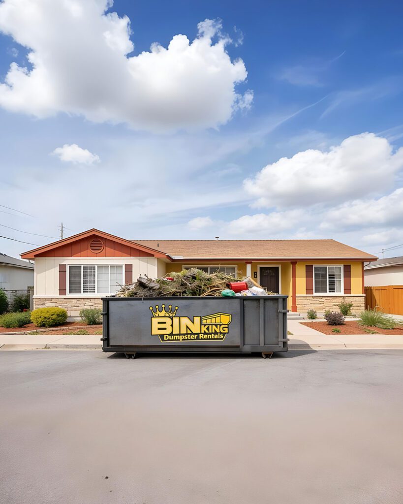Bin King dumpster placed in front of a residential home, ideal for home cleanouts, remodeling, roofing projects, and yard debris removal.