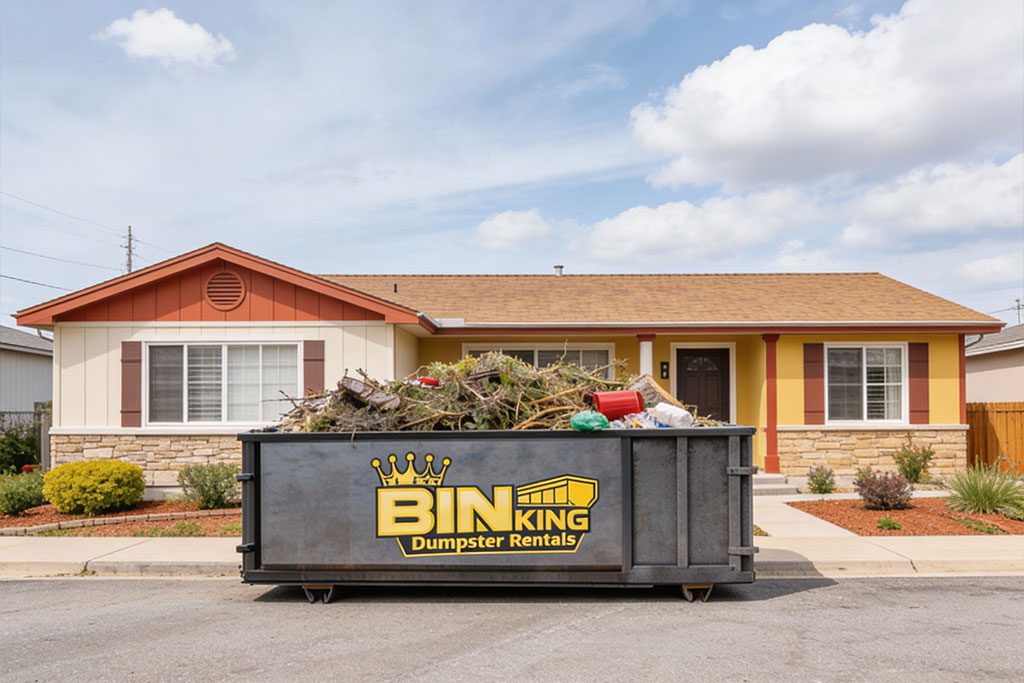 Small Bin King dumpster parked in front of a single-family home, ideal for DIY projects and weekend home cleanups.
